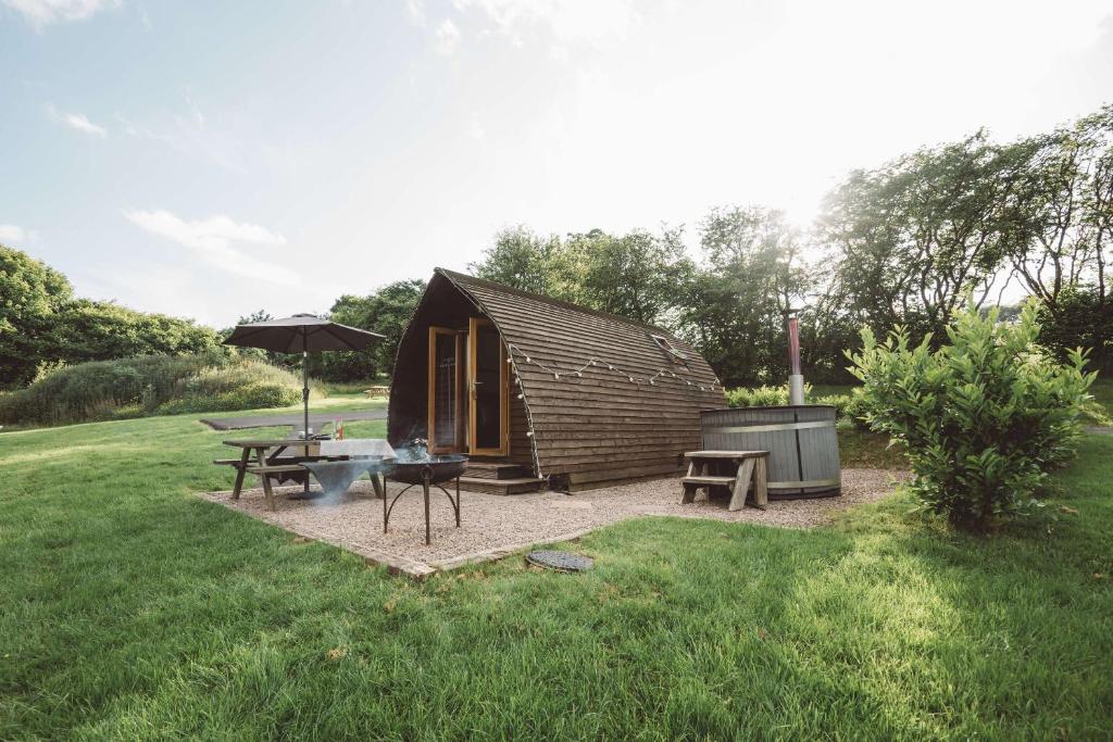 a small cabin with a picnic table and an umbrella at Brecon by Wigwam Holidays in Brecon