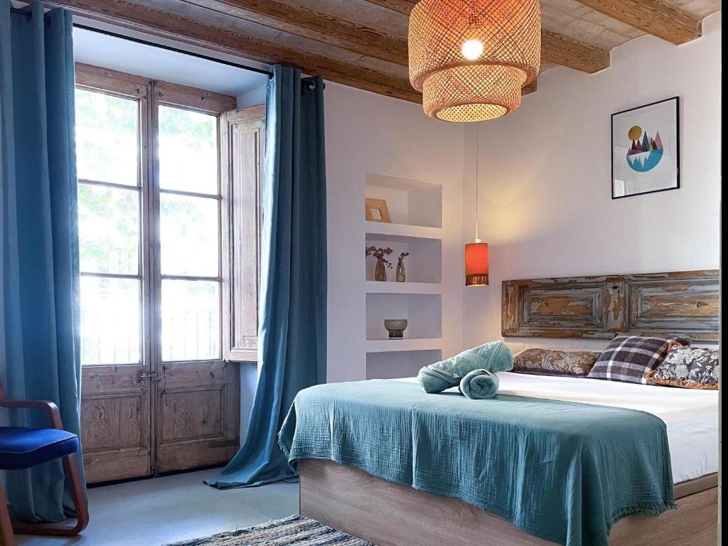 a bedroom with a bed with a blue blanket at Apartment Rafol in Vilanova i la Geltrú