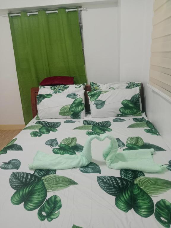 una camera con un letto e un piumone verde e bianco di Mactan Oasis gardens condominium a Lapu Lapu City