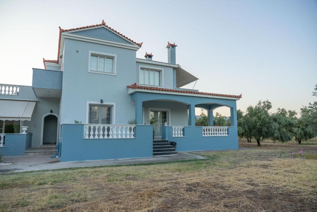 a white house with a blue at Kalloni Olive House in Kalloni