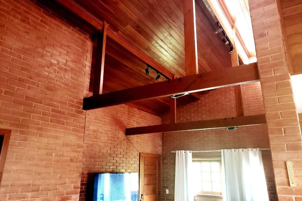a ceiling light in a room with a brick wall at Casas perto cervejaria 3 Santas in Santa Teresa