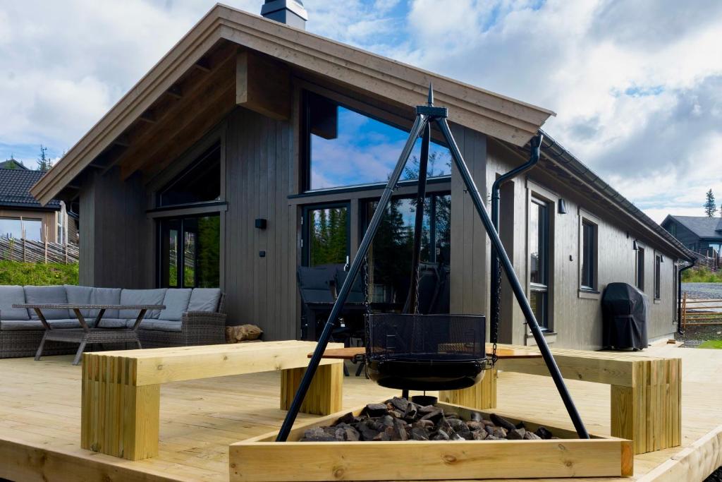 a tiny house on a deck with a fire pit at New cabin at Skeikampen, perfect for families! in Svingvoll