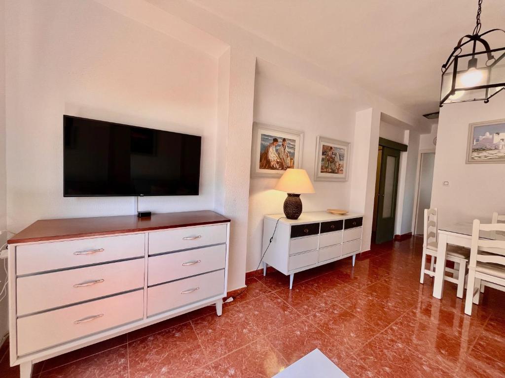 a living room with a flat screen tv on a dresser at Luz, sol y arena in Rota