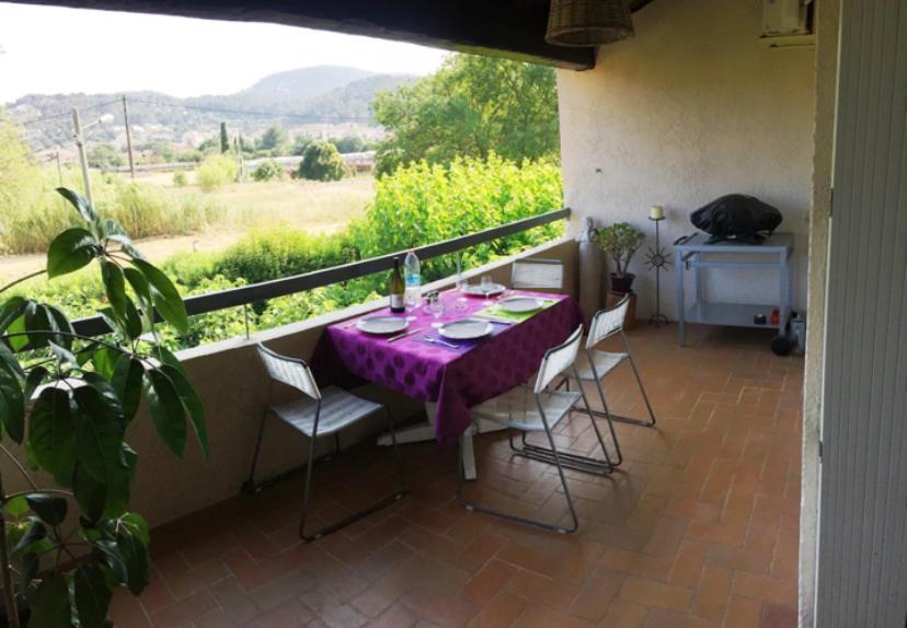 une table avec un chiffon de table violet sur un balcon dans l'établissement Beau T3 Calme et idéalement situé à Hyères, à Hyères
