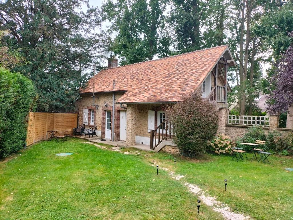 mały ceglany dom z ogrodzeniem i ogródkiem w obiekcie La maison du four à pain w mieście Grandchamp