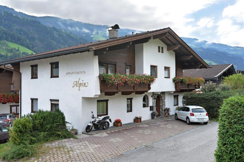 una casa blanca con una motocicleta estacionada frente a ella en Apartment Alpin, en Aschau