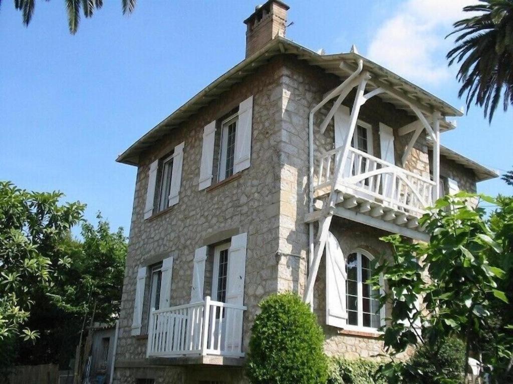 Un grand bâtiment en briques avec un balcon est disponible. dans l'établissement Villa 12MN Walk from le palais, à Cannes