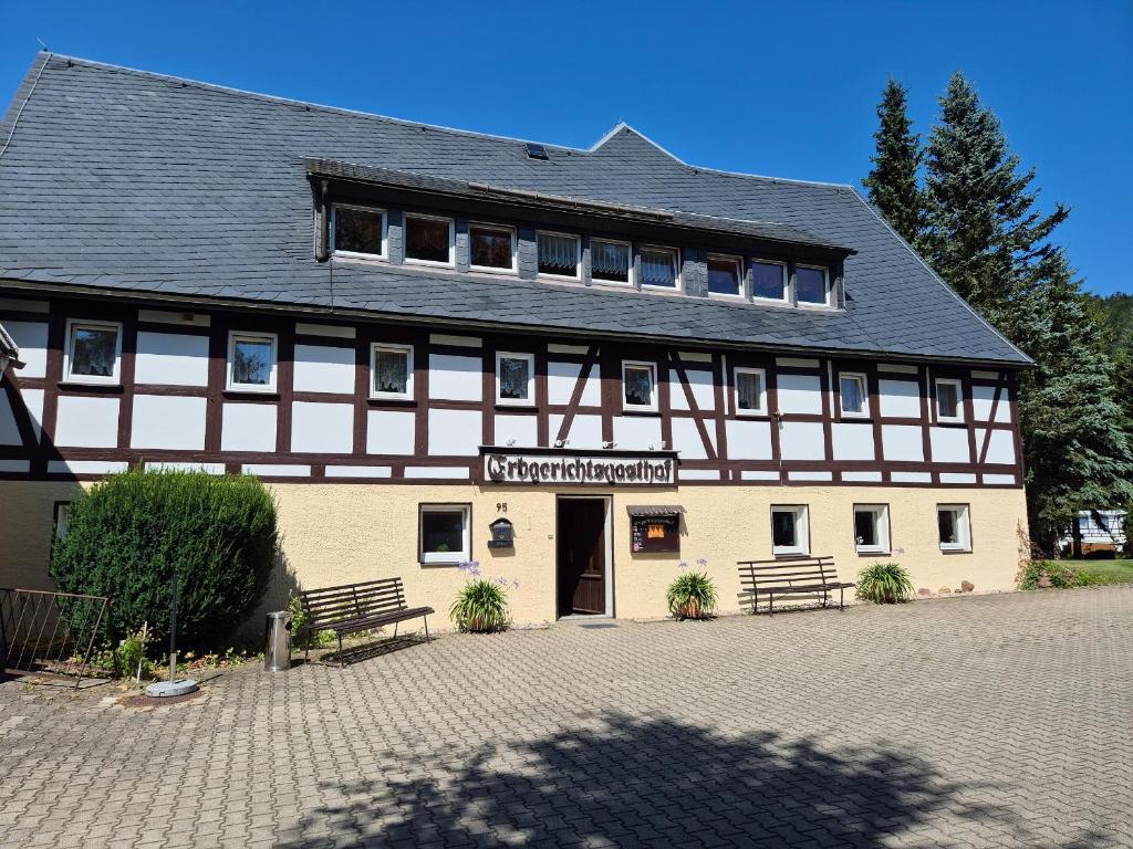 a large building with a black and white building at Erbgerichtsgasthof Holzhau in Bienenmühle