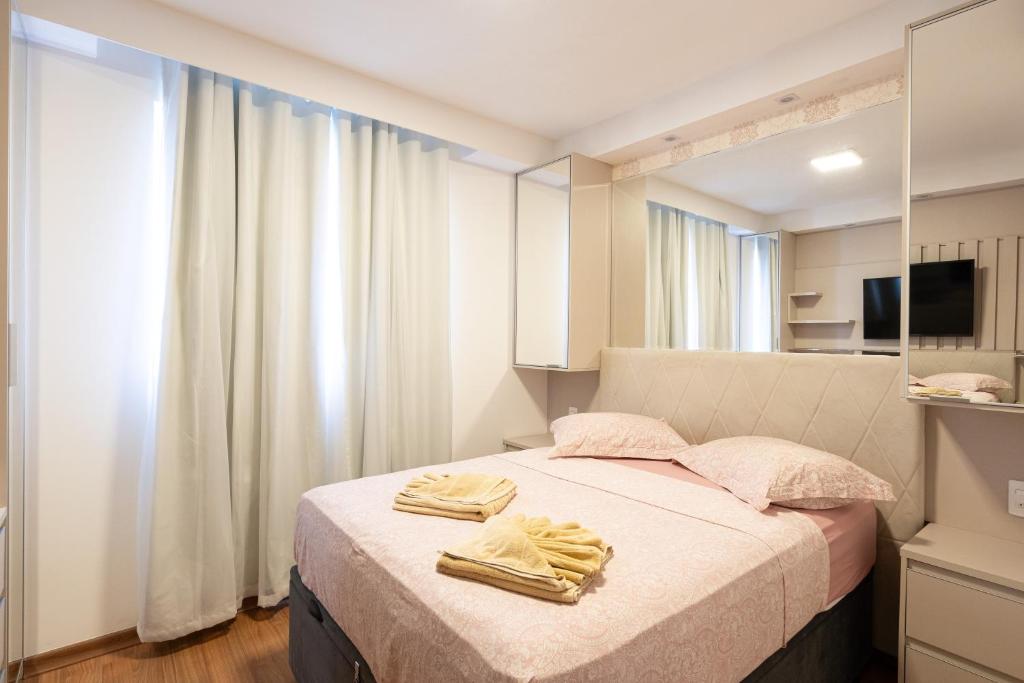 ein Schlafzimmer mit einem Bett mit zwei Handtüchern darauf in der Unterkunft Aptos completos com vista mar pé na areia em Barra Velha em condomínio Resort com Spa, Piscina, quadra de futebol, Sala de jogos, brinquedoteca, Complexo com diversos comércios in Barra Velha