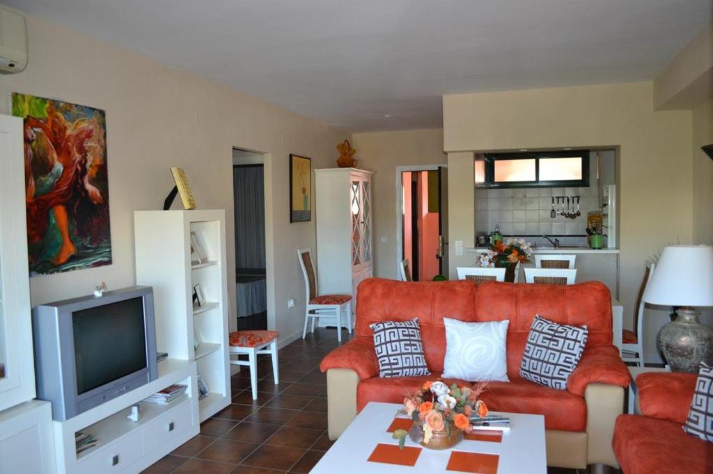 sala de estar con sofá rojo y TV en Apartamento Zahara De Los Atunes, en Zahara de los Atunes