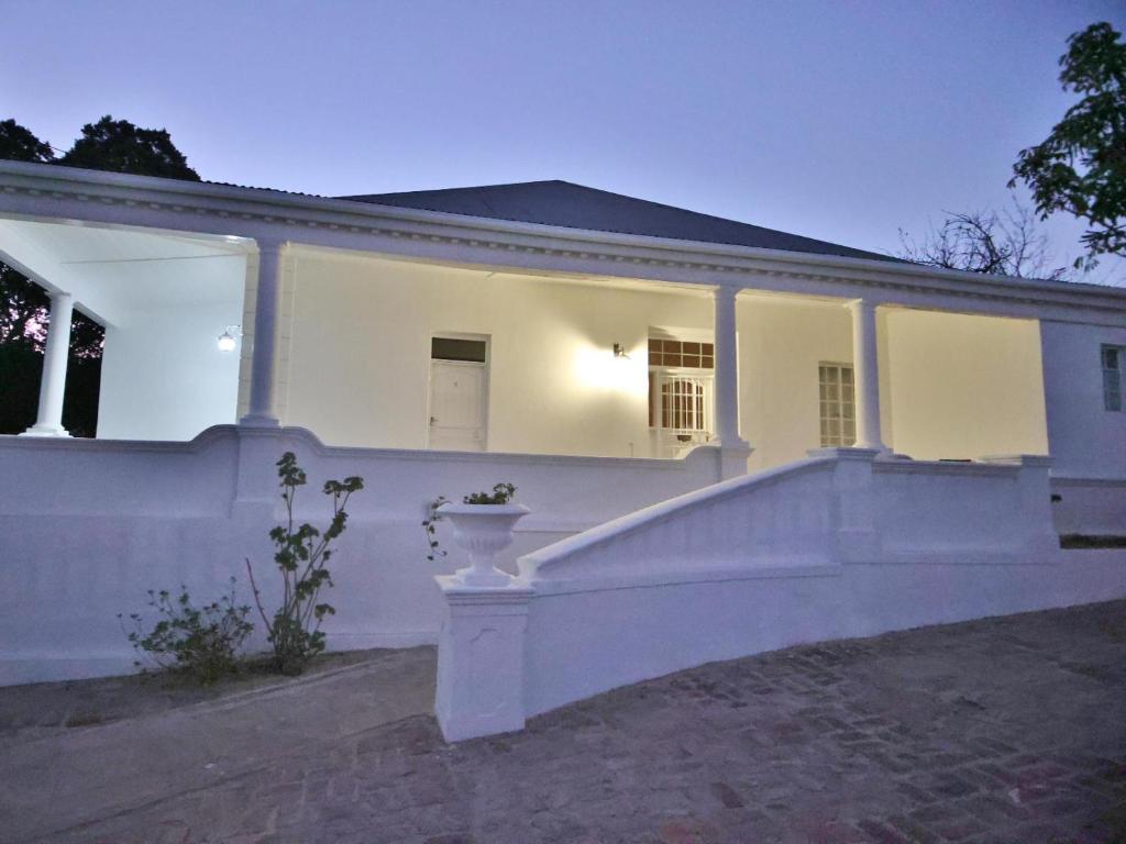 a white house with a white wall at Lilibet Lodge in Graaff-Reinet