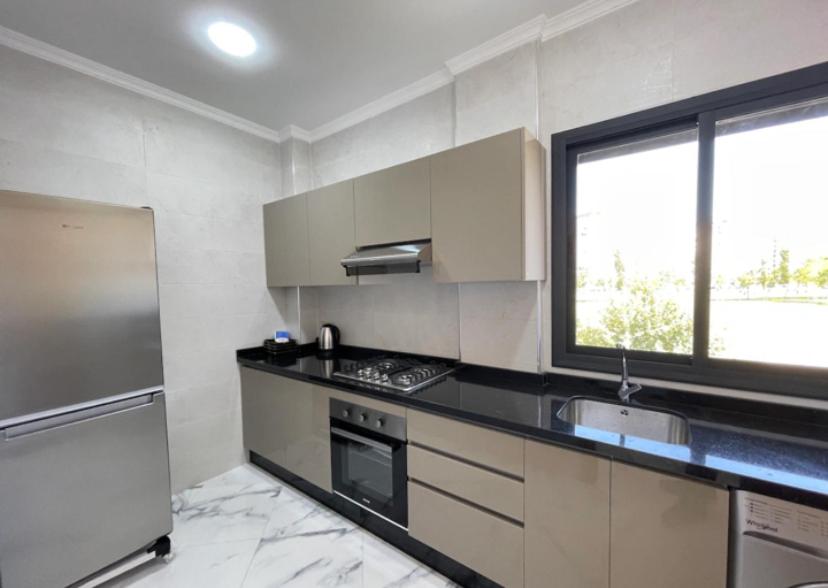 a kitchen with a black counter top and a window at Yaluna Appart'hôtel & Restaurant in Tangier