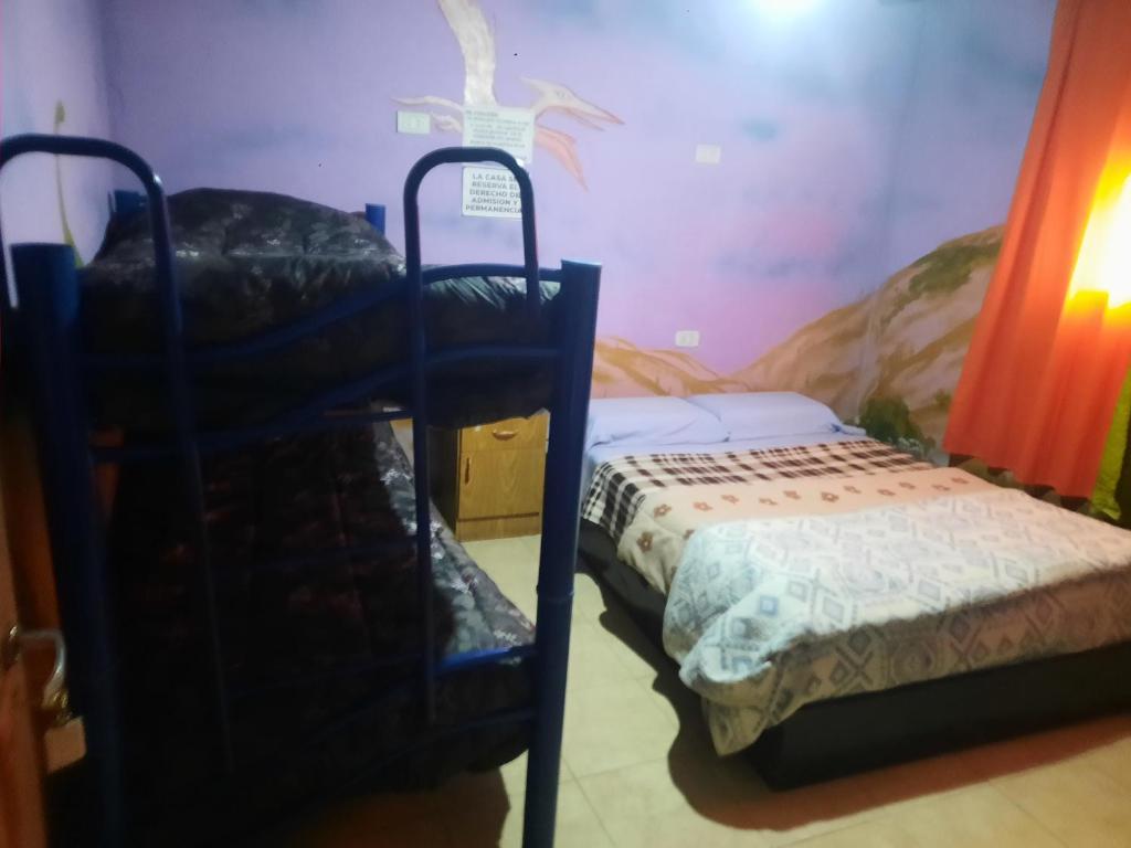 a bedroom with a bunk bed and a small bed at Hostel El Submarino in San Agustín de Valle Fértil