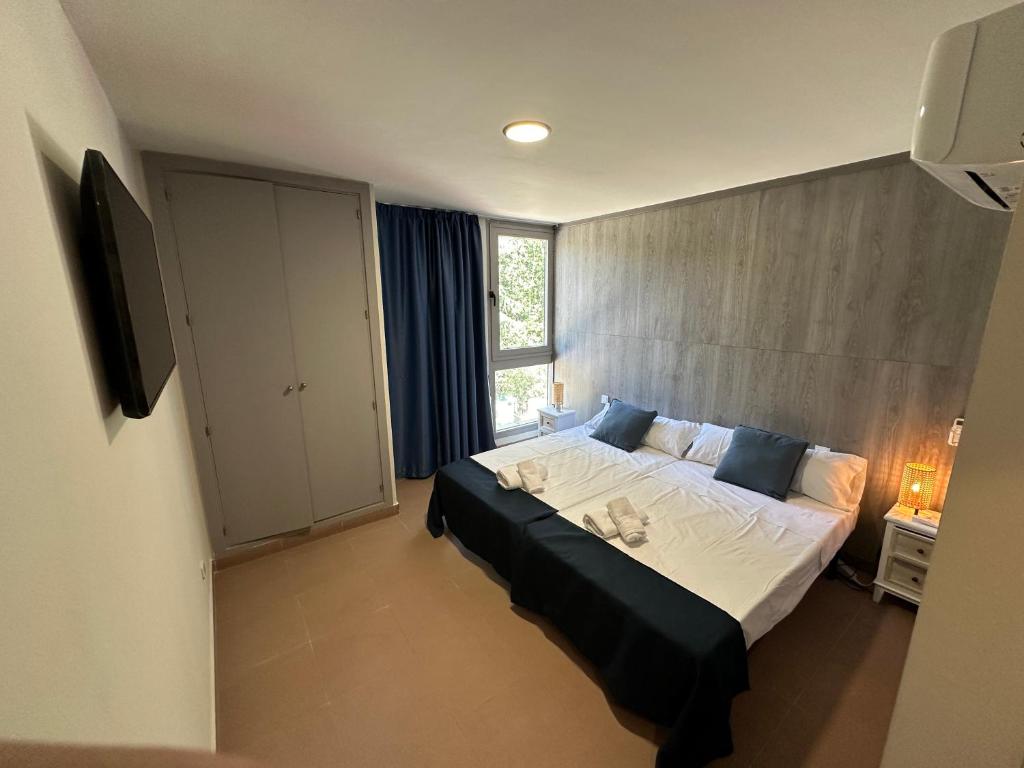 un dormitorio con una cama grande y una ventana en Hostal MYD Pantano, en Pelayos de la Presa