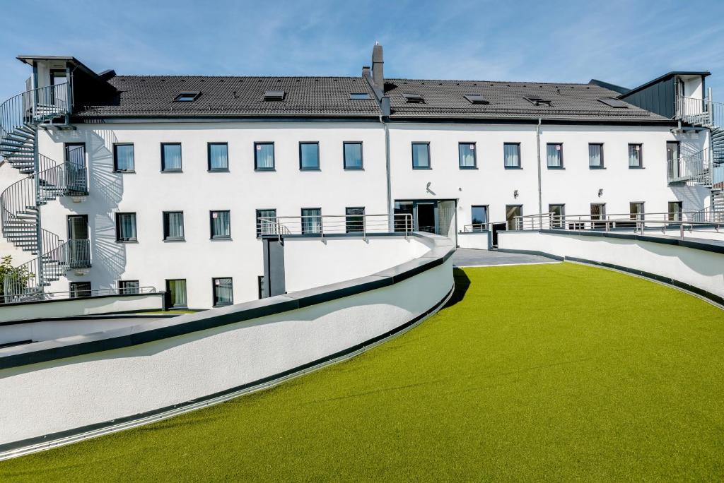 Un gran edificio blanco con césped verde delante. en Hotel Montenegro, en Worms