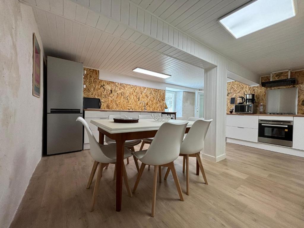 une cuisine et une salle à manger avec une table et des chaises dans l'établissement Maison Spacieuse en Ville, à Poitiers