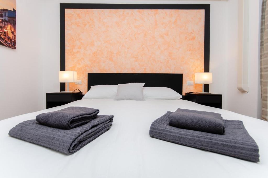 un lit blanc avec deux oreillers dessus dans l'établissement Orange Room, à Milan