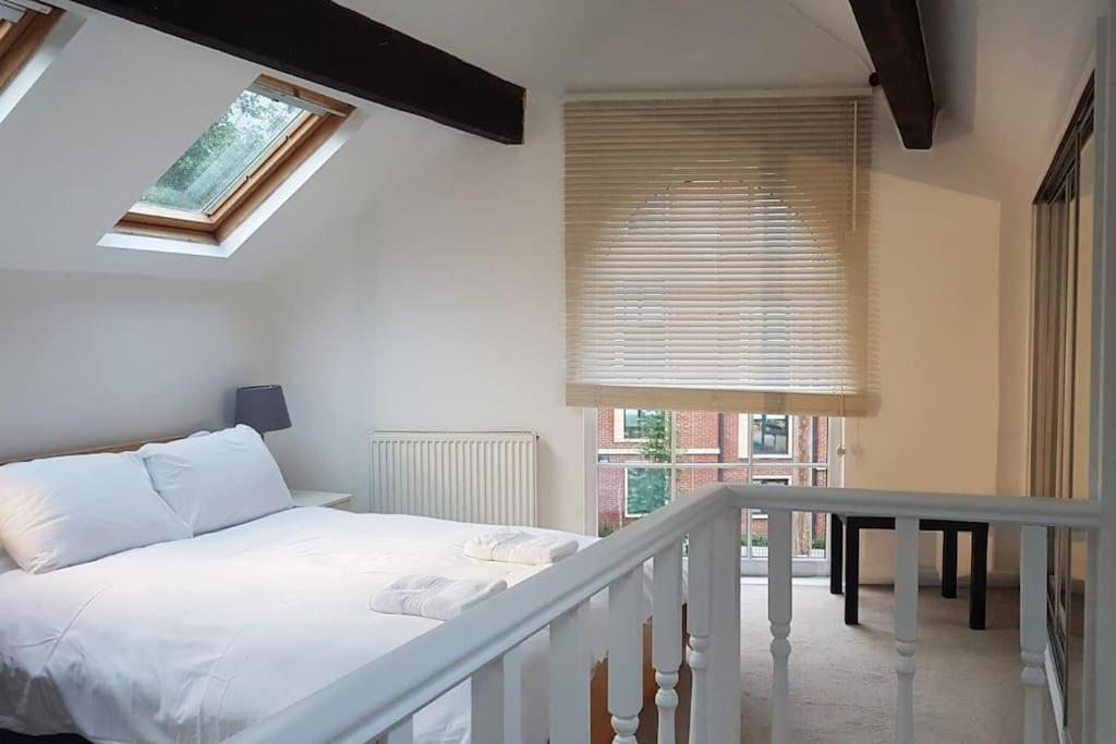 a bedroom with a bed and a table and a window at Charming cottage central Leeds close to LGI in Leeds