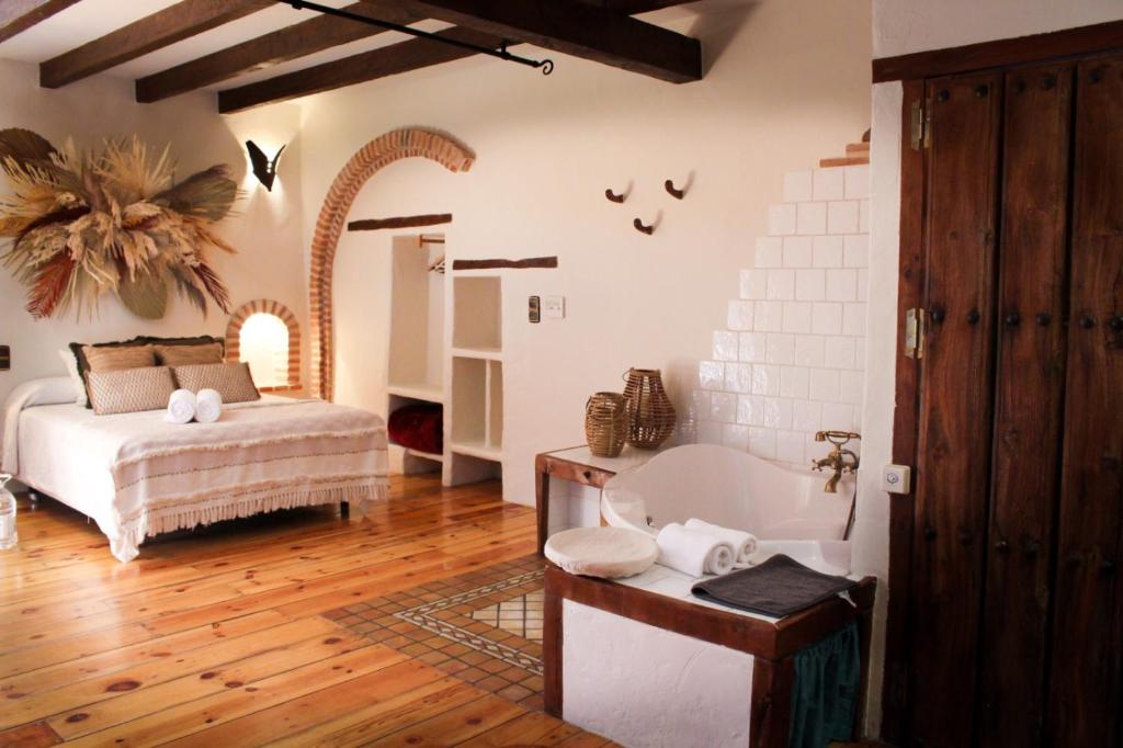 un dormitorio con una cama y una bañera en Apartamento Candeal, en Olmedo
