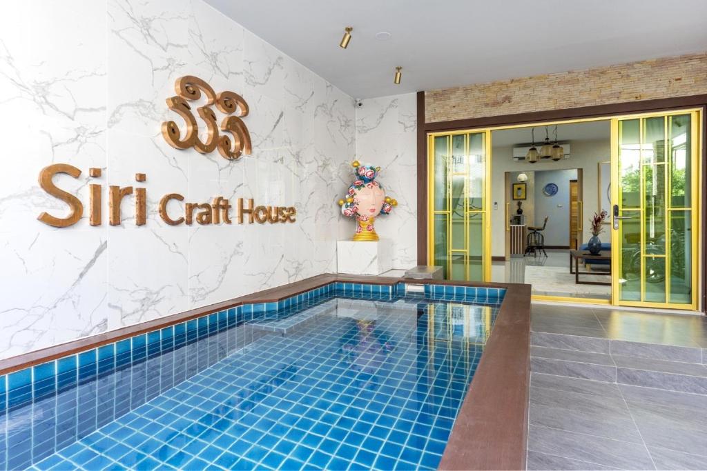 een zwembad met een bord waarop staat: roer chi chi heeft bij 4BR Luxury Pool Villa Siri Craft House Nimman in Chiang Mai