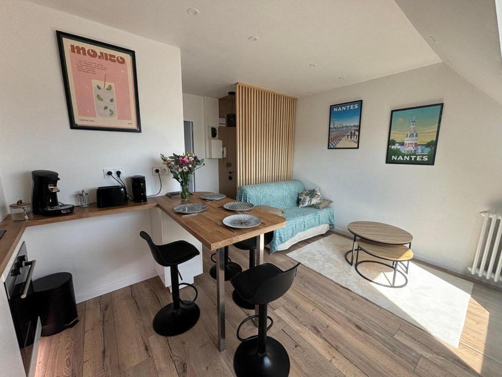 un salon avec une table, des chaises et un canapé dans l'établissement T2 Centre ville proche gare - Tramway au pied, à Nantes