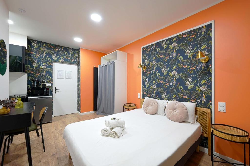 une chambre avec un grand lit blanc avec des murs orange dans l'établissement Modern secure studio- perfect for 2- Catacombs, à Paris