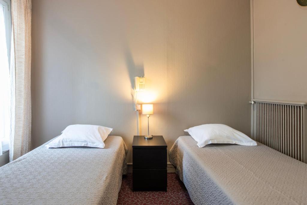 two beds sitting next to each other in a room at Grand Hôtel De Paris in Paris