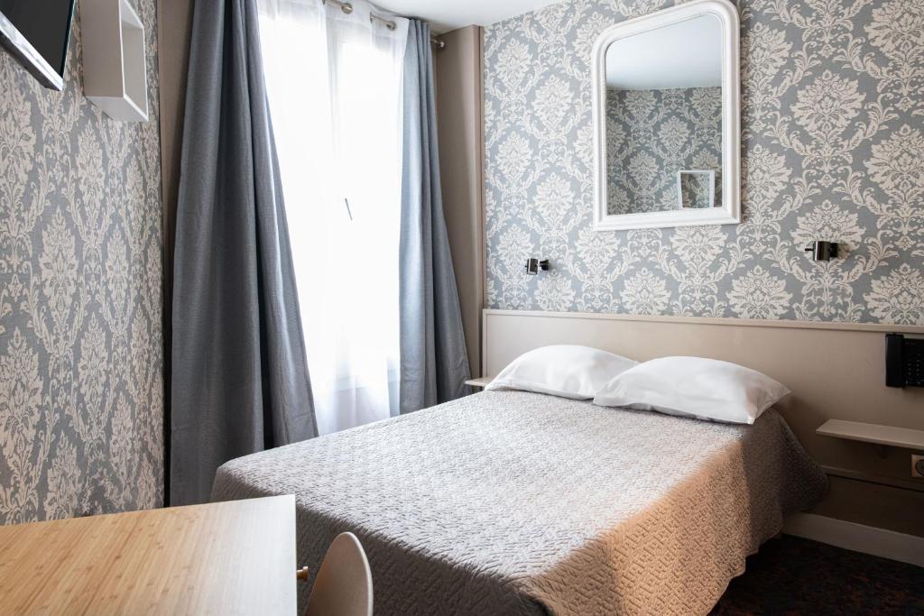 a hotel room with a bed and a mirror at Grand Hôtel De Paris in Paris