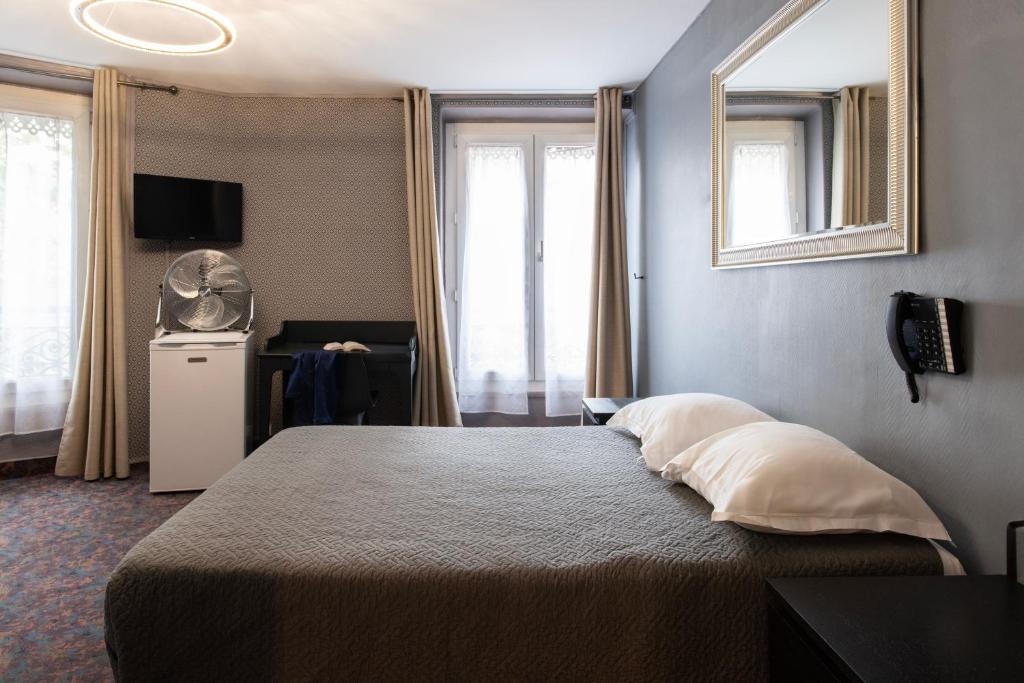 a hotel room with a large bed and a desk at Grand Hôtel De Paris in Paris