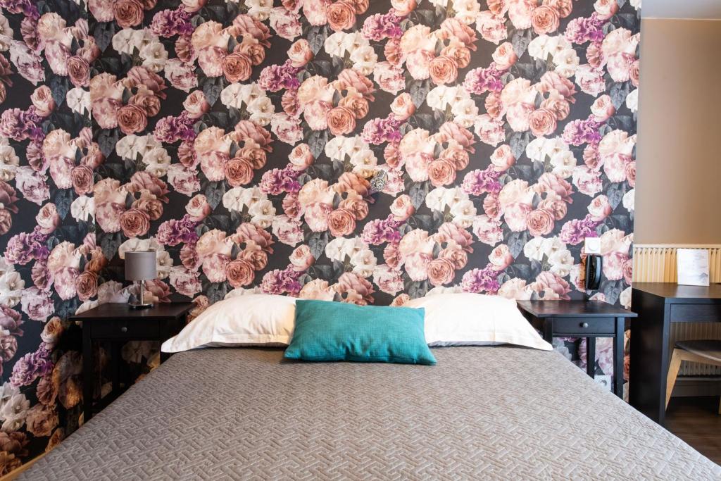 a bedroom with a floral wallpaper and a bed with a pillow at Grand Hôtel De Paris in Paris