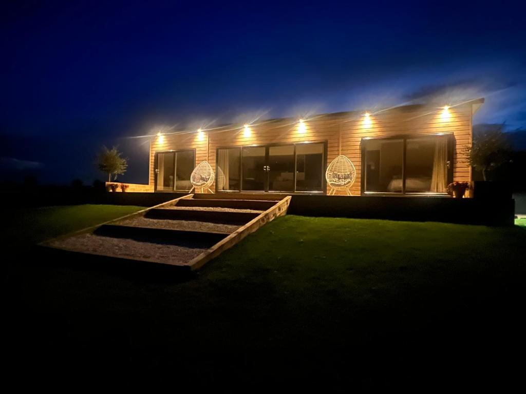 a house lit up at night with lights at Phoenix Lodge - Luxury 2 ensuite bedrooms, lakeside views in Newark upon Trent