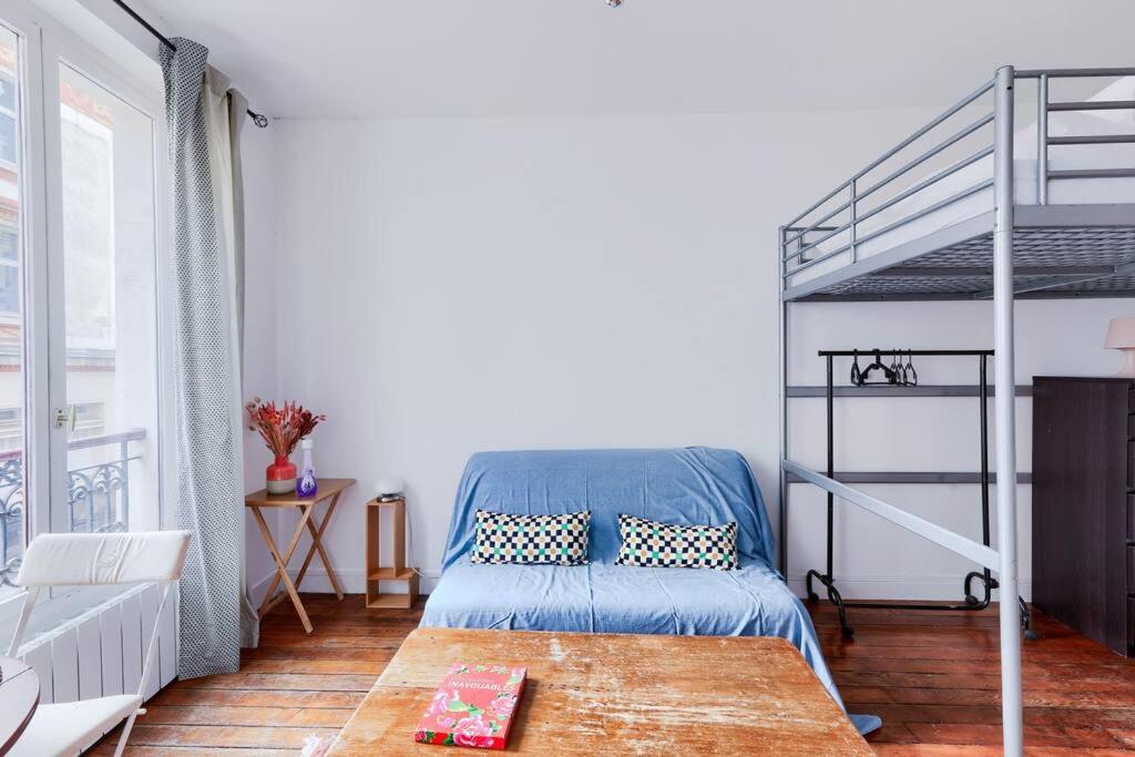 une chambre avec un lit superposé et une échelle dans l'établissement Studio pour 3 - Confort Moderne, Proche Métro, à Paris