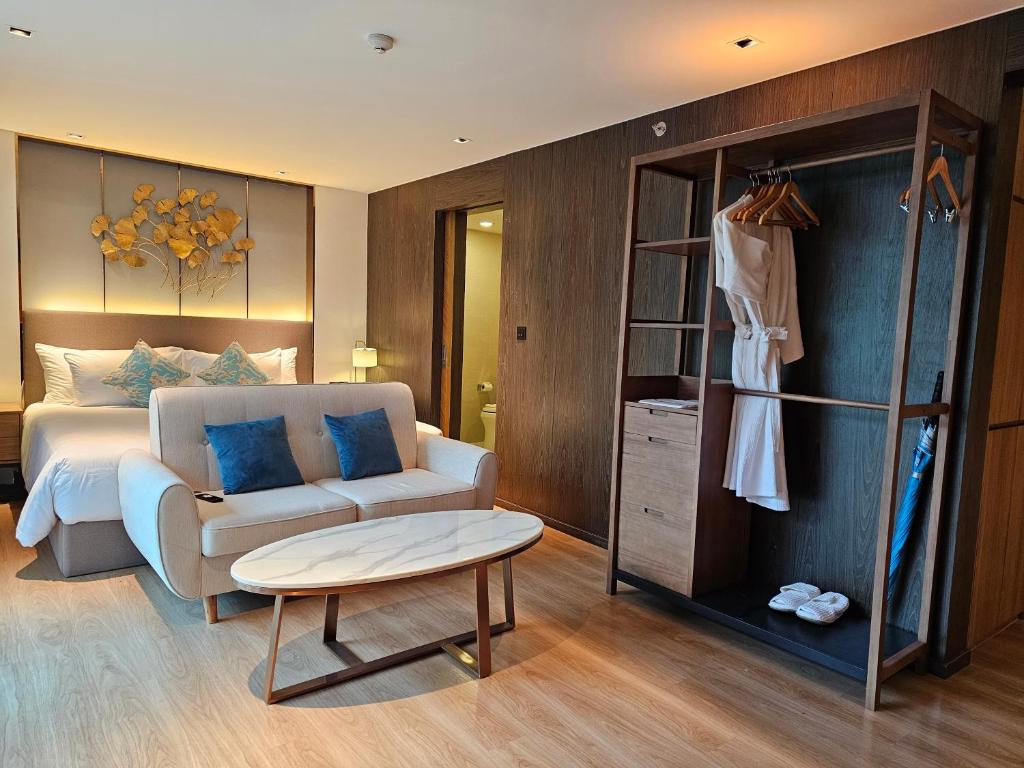 a bedroom with a bed and a chair and a table at La Vita Luxury Apartment in Rawai Beach