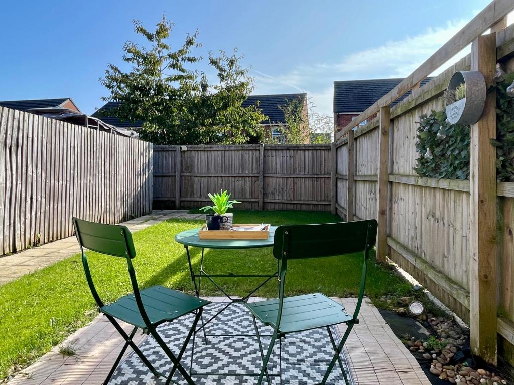 a patio with two chairs and a table in a backyard at Modern 2-Bed Townhouse in Kirkdale in Liverpool