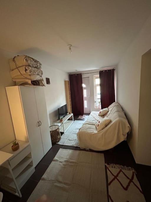 a small bedroom with a bed and a desk at Chaleureux studio 3km de Luxembourg in Audun-le-Tiche