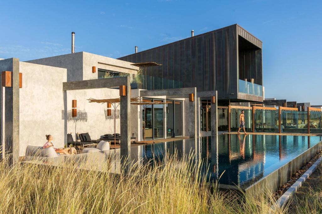 uma casa com uma piscina na frente em Areias do Seixo Hotel em Santa Cruz