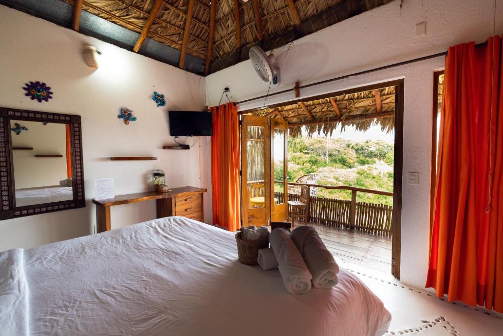 een slaapkamer met een bed en een deur naar een balkon bij Hotel Boutique at Cuatunalco in Cuatunalco