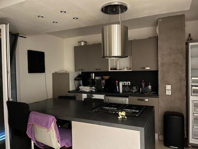 une cuisine avec un comptoir noir dans une pièce dans l'établissement Location maisonnette avec jardinet, à Vallauris