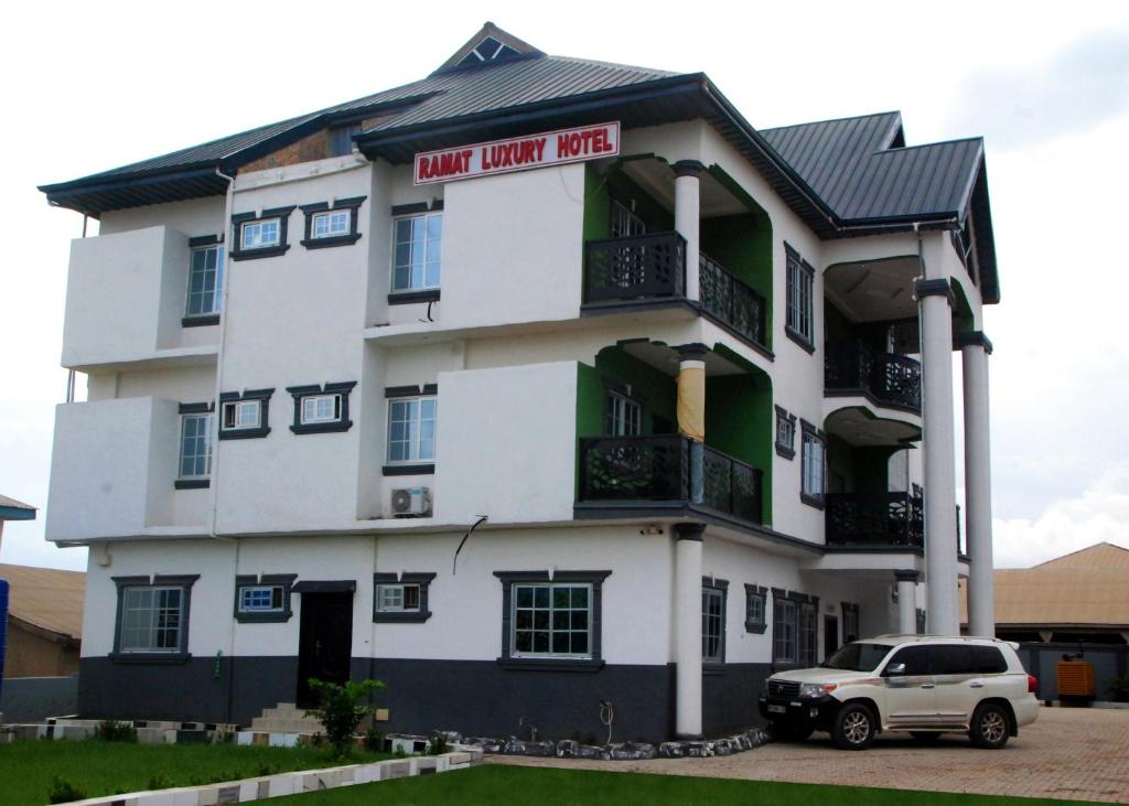 a white car parked in front of a building at Ramat Luxury Hotel in Mangpontin