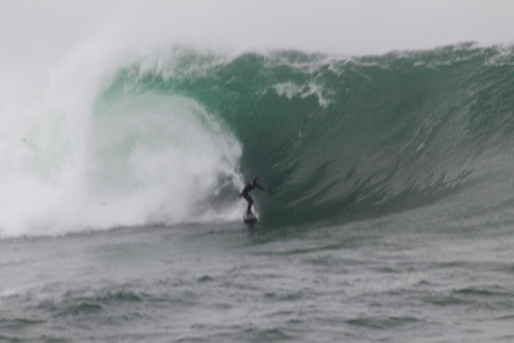 a person riding a wave on a surfboard in the ocean at In The Woods in Ballintogher