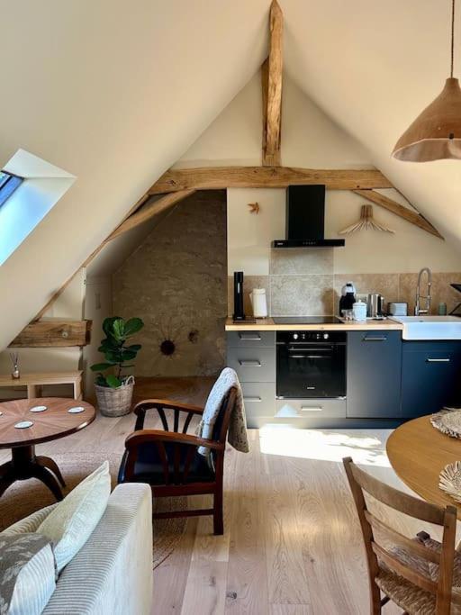 un salon avec un canapé et une table et une cuisine dans l'établissement Appartement à l'abri du donjon, à Loches