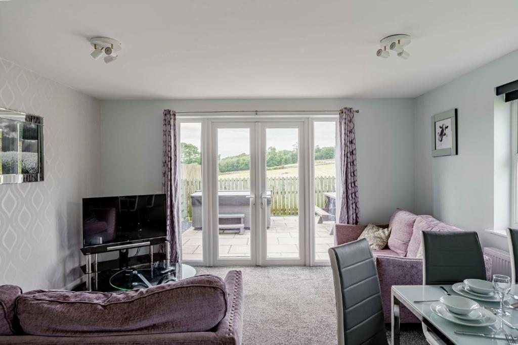 a living room with a couch and a tv at Auchenlarie Courtyard No 4 in Gatehouse of Fleet