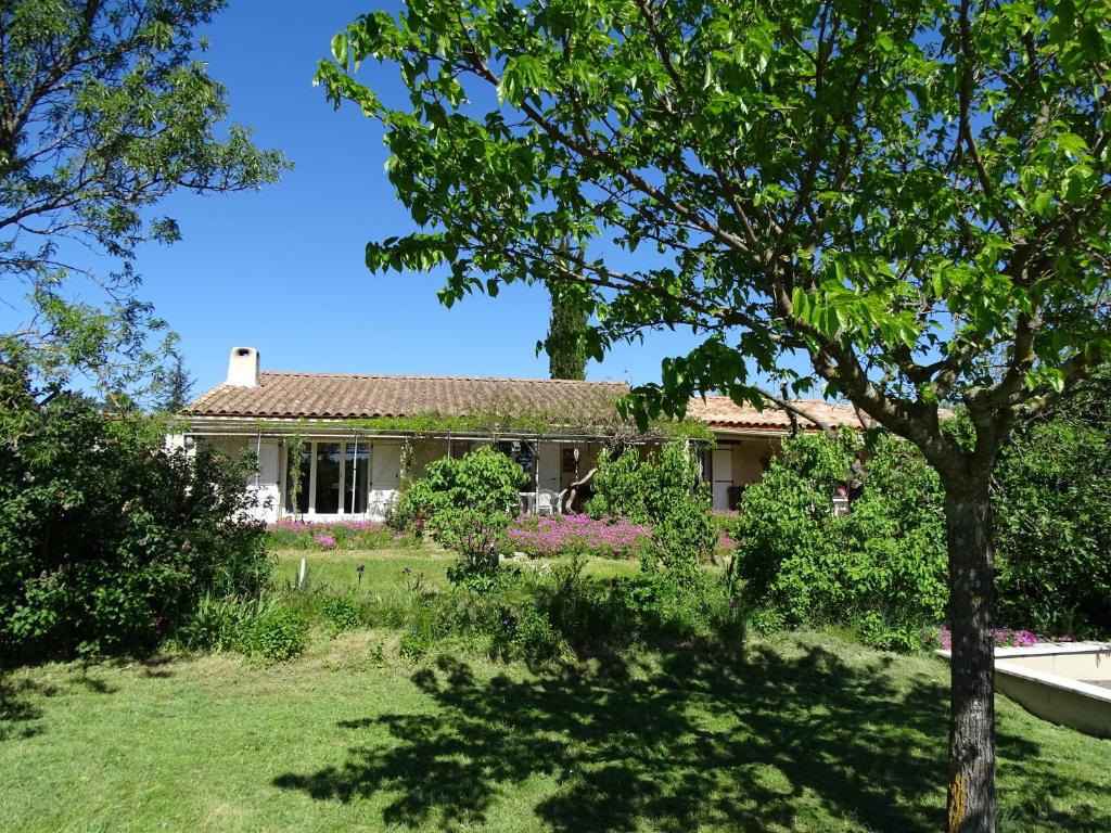 une maison avec un arbre en face d'une cour dans l'établissement Studio idépendant au rez de chaussée d'une longère terrasse , jardin , mezzanine 1 lit double , 2 matelas sur mezzanine , hauteur limitée pour enfants, à Saint-Ambroix