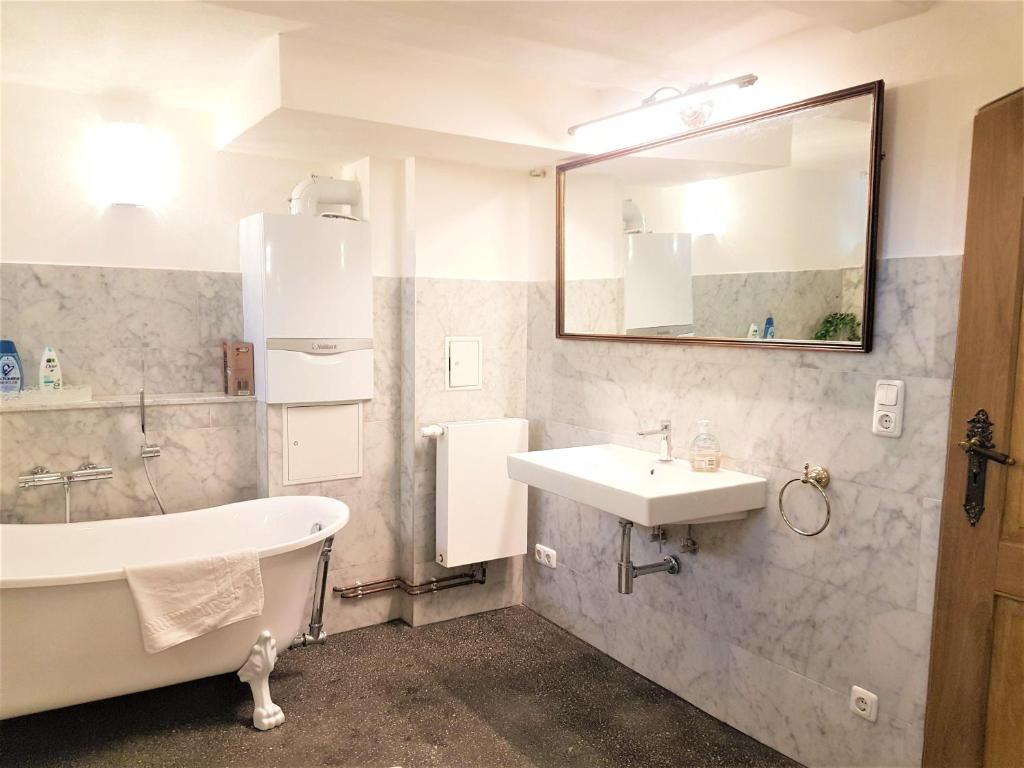 a bathroom with a tub and a sink and a bath tub at Deluxe-Appartement-70m2-mit-Fruehstueck-Gruppenunterkuenfte-im-Oberharz in Sankt Andreasberg