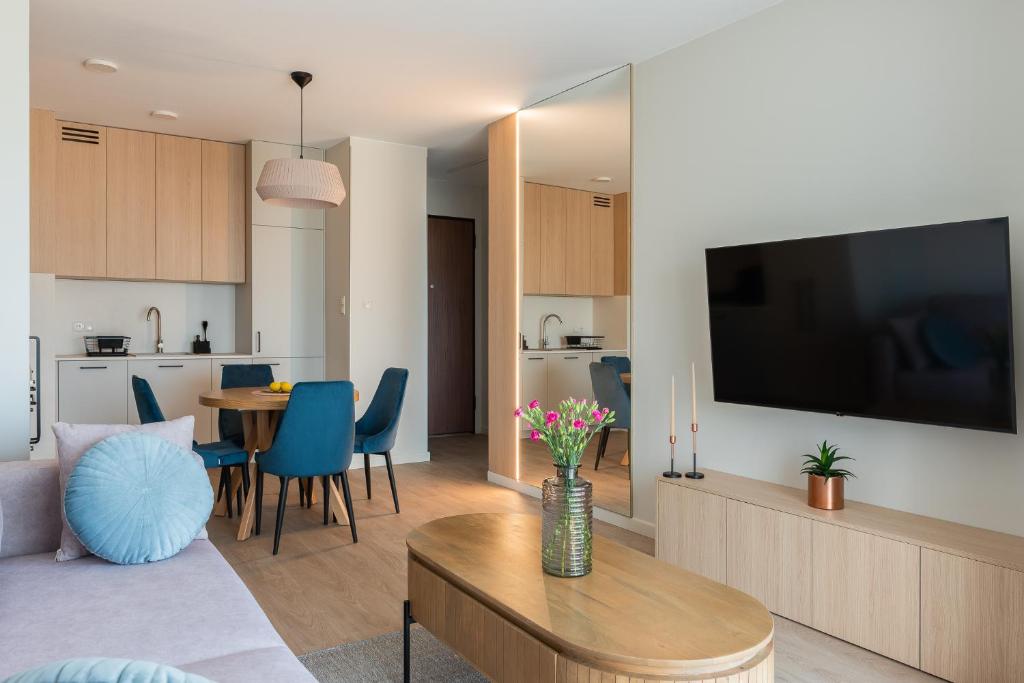 Hotel Sienna Grobla Old Town Apartment, a living room with a couch and a table with a television at Sienna Grobla Old Town Apartment in Gdańsk