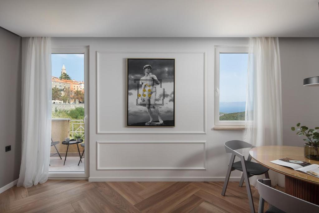 a living room with white walls and a picture of a woman at Canova Apartment in Labin