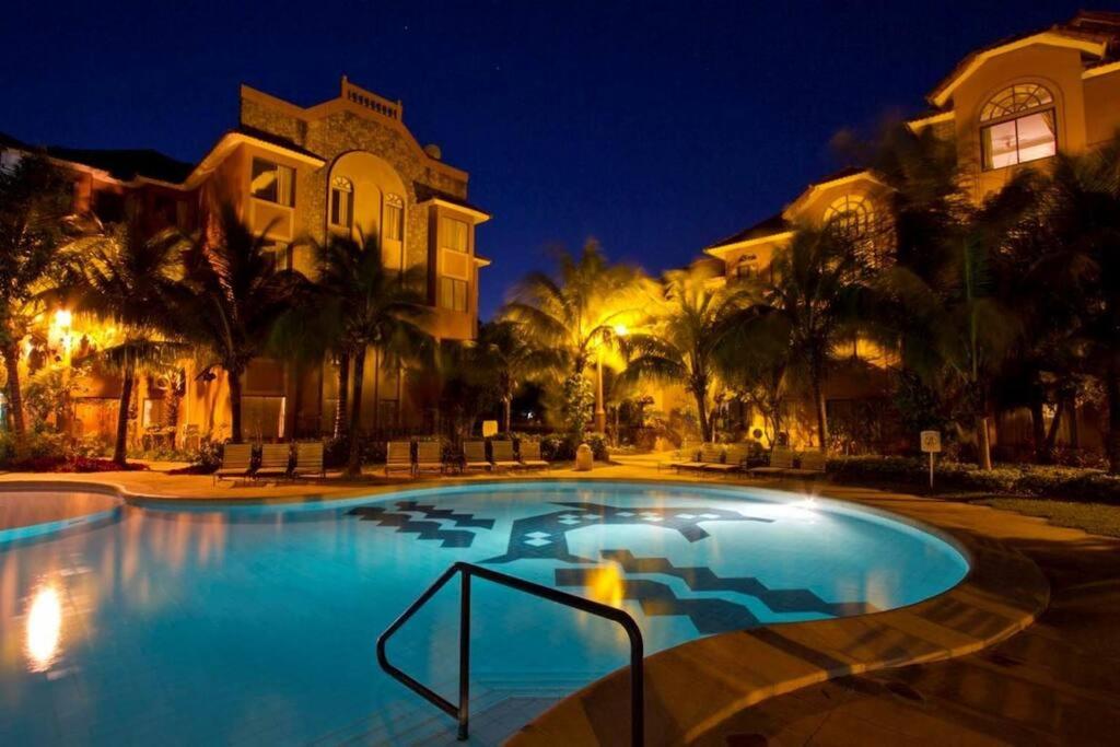 een groot zwembad voor een huis 's nachts bij Hermoso Duplex Hotel BUGANVILLAS in Santa Cruz de la Sierra