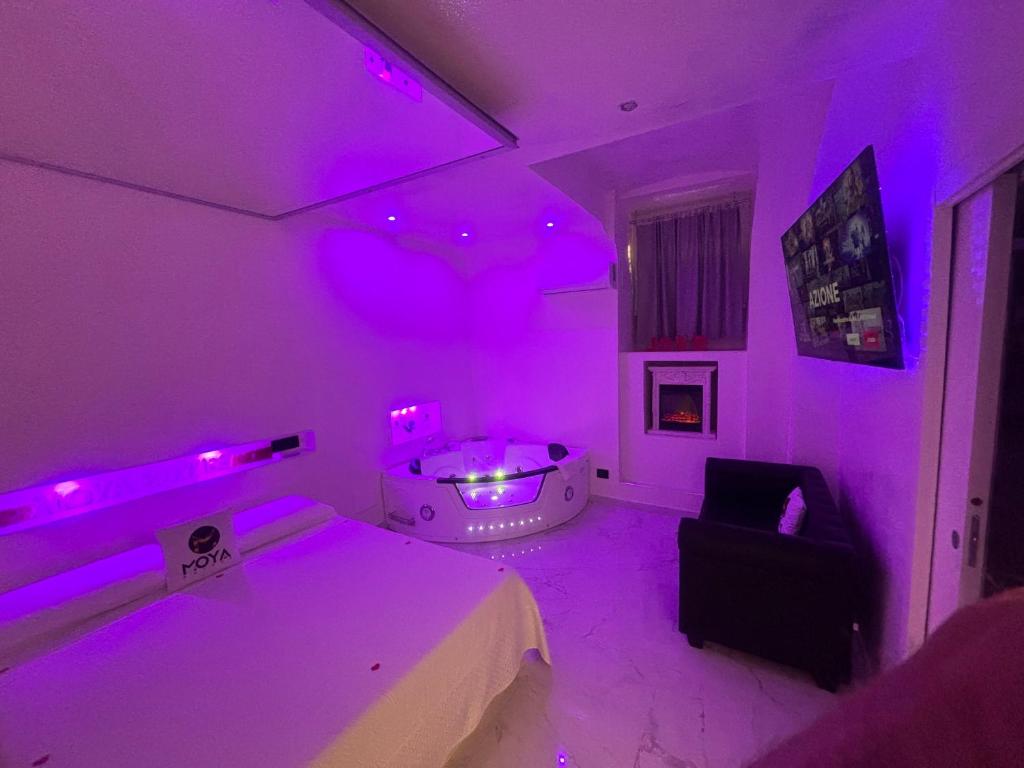 Habitación púrpura con cama y silla en Moya Suites 2 - SPA in Camera, en Roma
