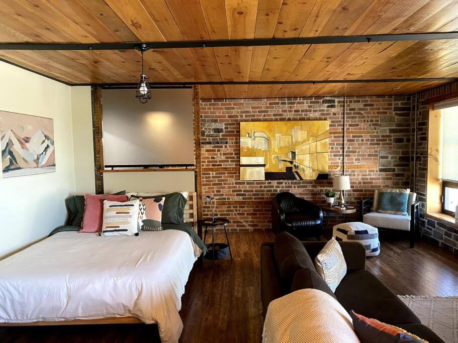 a bedroom with a bed and a brick wall at Cozy downtown studio getaway in Kingston