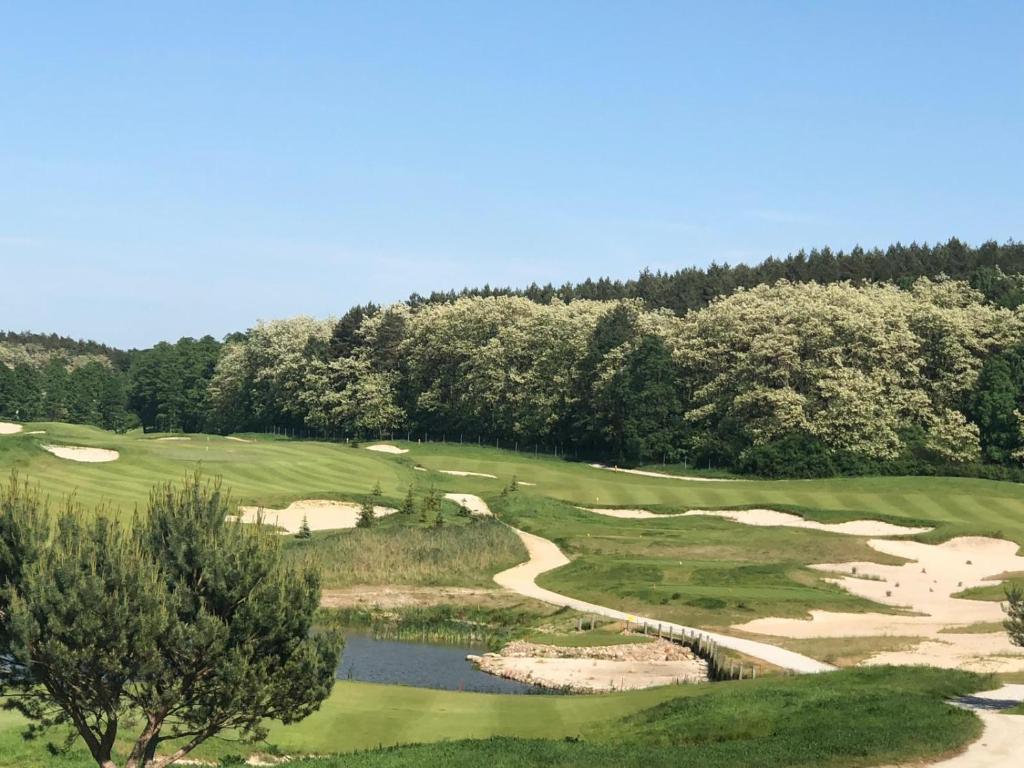 vista aerea su un campo da golf con laghetto di Przytok Golf Resort a Przylok